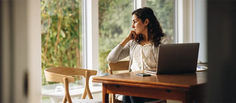 Adult seated at a desk in a calm home environment during telehealth therapy